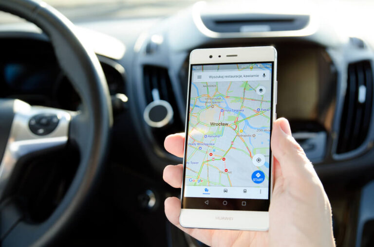 Kierowca trzyma telefon Huawei, na którym wyświetla się mapa Wrocławia