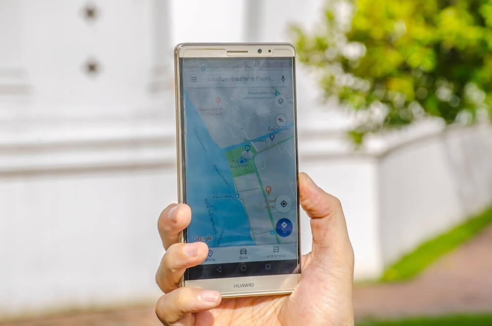 Osoba trzyma telefon Huawei z aplikacją Google Maps